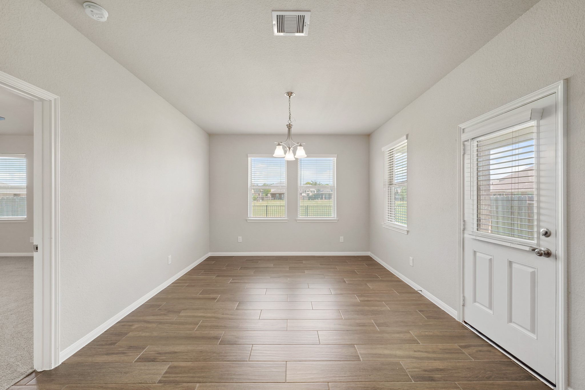 6010 Kolle Drive Rosenberg, TX 77471 - Photo 19 of 45 an empty room with wooden floor and windows