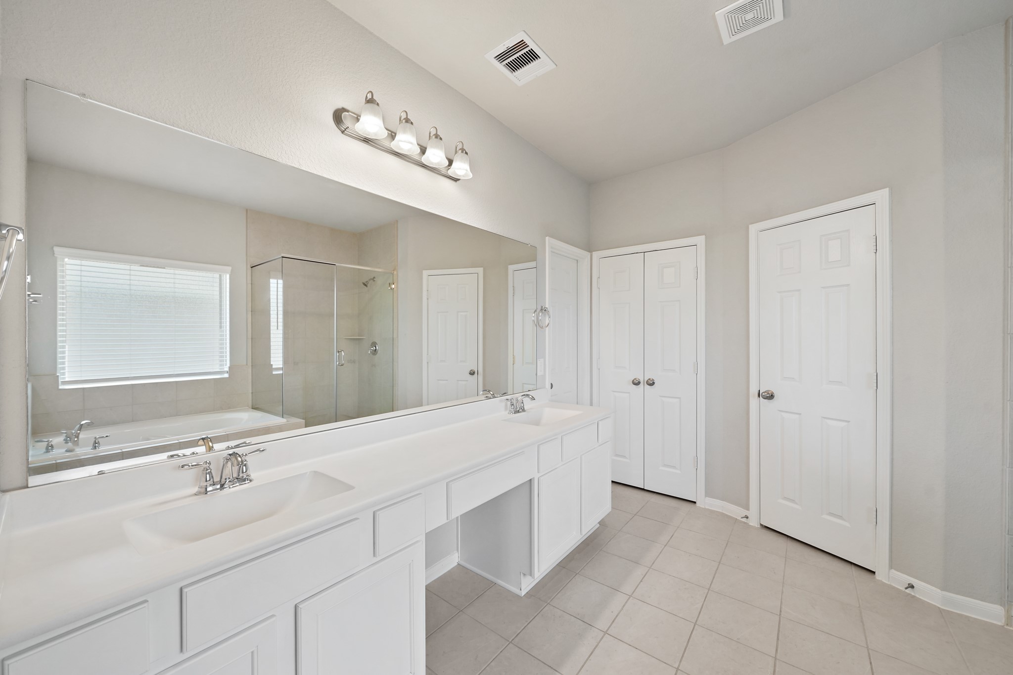 6010 Kolle Drive Rosenberg, TX 77471 - Photo 27 of 45 a spacious bathroom with a double vanity sink a large mirror and a bathtub