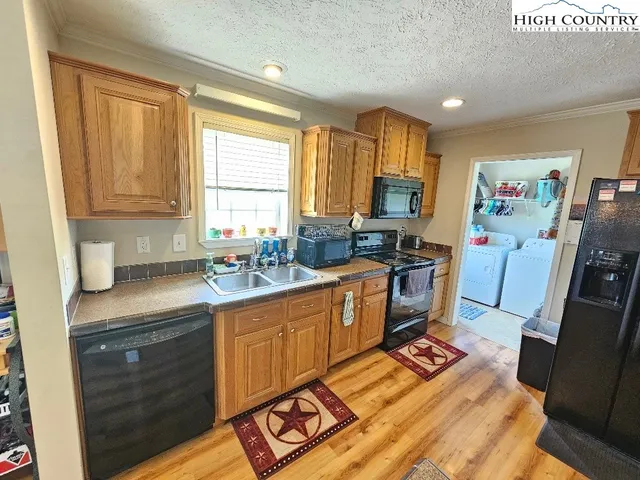 a kitchen with granite countertop a refrigerator a sink and dishwasher