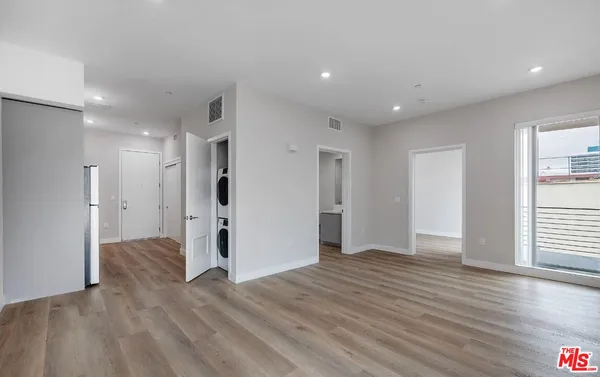 a view of empty room with wooden floor and window