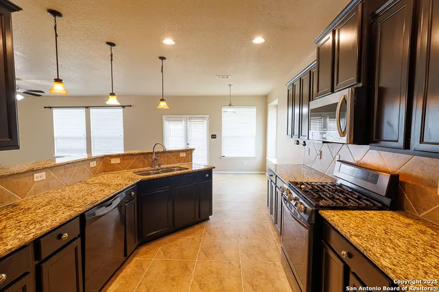 a kitchen with stainless steel appliances granite countertop a stove and a sink