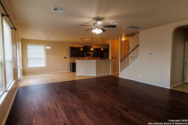 a view of a livingroom with wooden floor and a ceiling fan
