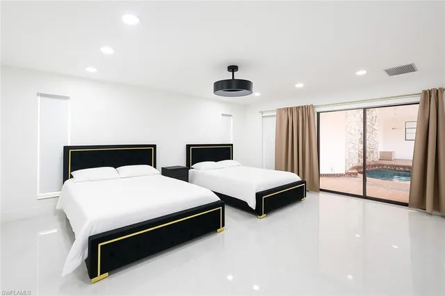 a bedroom with two beds and a large window