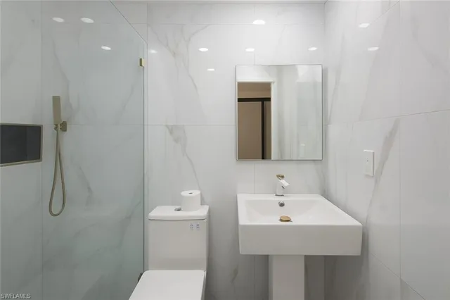 a bathroom with a sink a toilet and shower