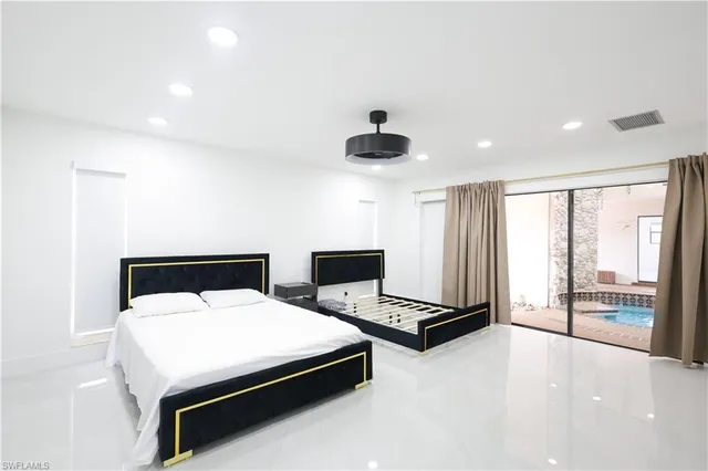 a bedroom with a bed and large windows