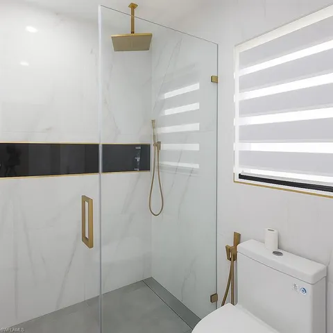 a bathroom with a shower a toilet and a sink