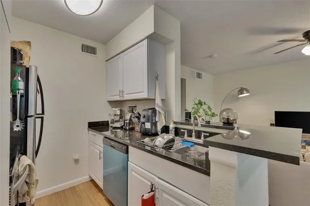 a kitchen with appliances a sink and cabinets