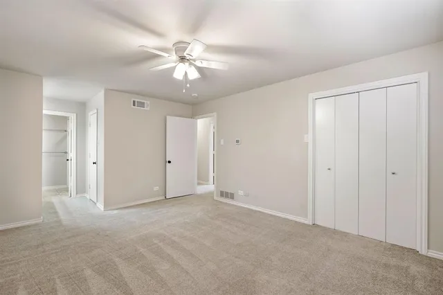 a view of an empty room and chandelier fan