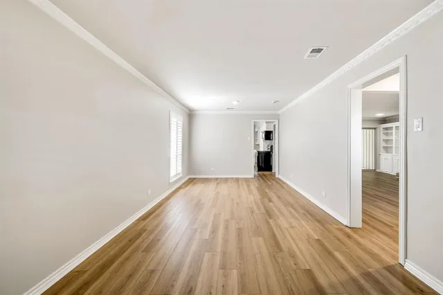 a view of empty room with wooden floor