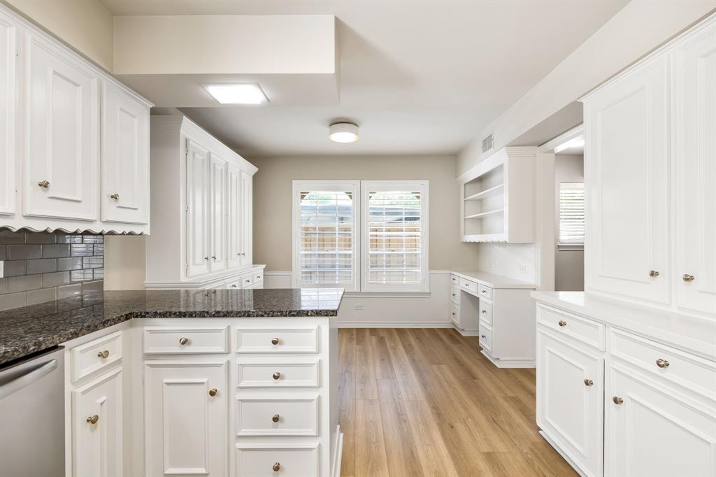 5921 Preston Road University Park, TX 75205 - Photo 10 of 37 a large white kitchen with granite countertop a large window white cabinets and sink