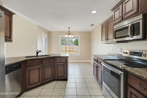 a kitchen with stainless steel appliances granite countertop a stove and a microwave