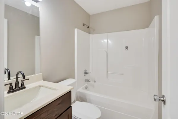 a bathroom with a bathtub shower sink vanity and toilet