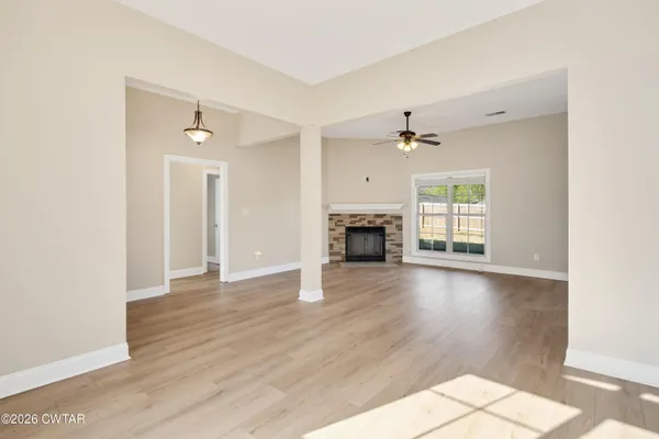 a view of empty room with a fireplace and wooden floor