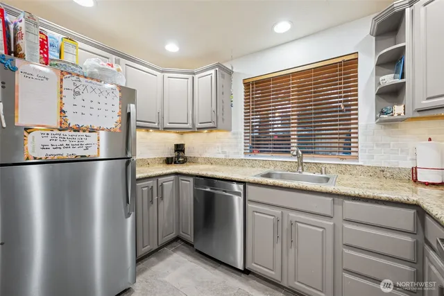a kitchen with granite countertop a sink stainless steel appliances and cabinets