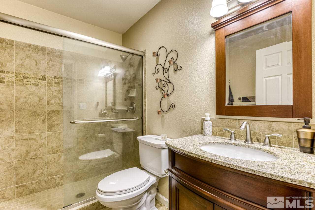 2330 Enterprise Road Reno, NV 89521 - Photo 21 of 40 a bathroom with a granite countertop sink a toilet and shower