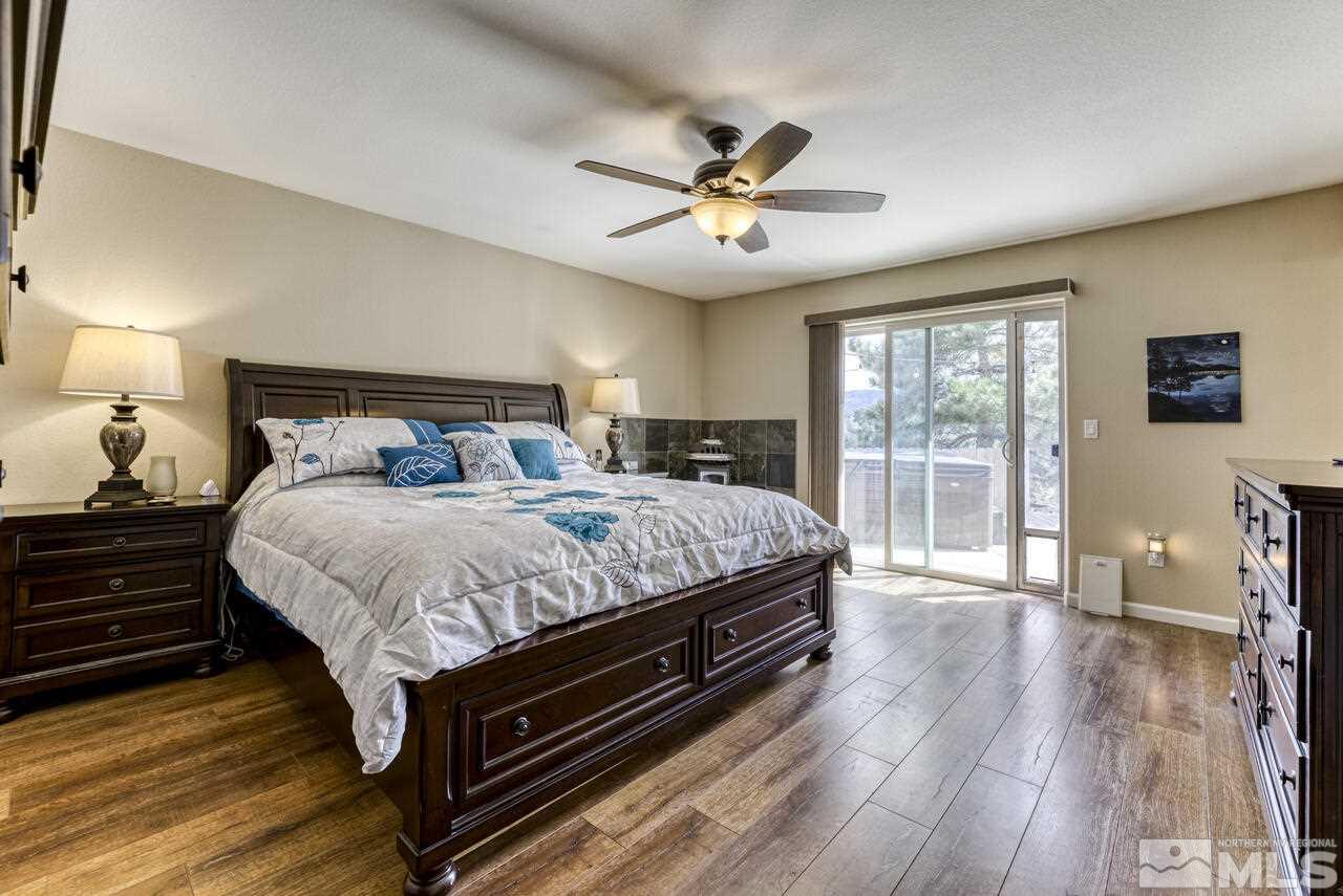 2330 Enterprise Road Reno, NV 89521 - Photo 24 of 40 a bedroom with a bed a window and wooden floor