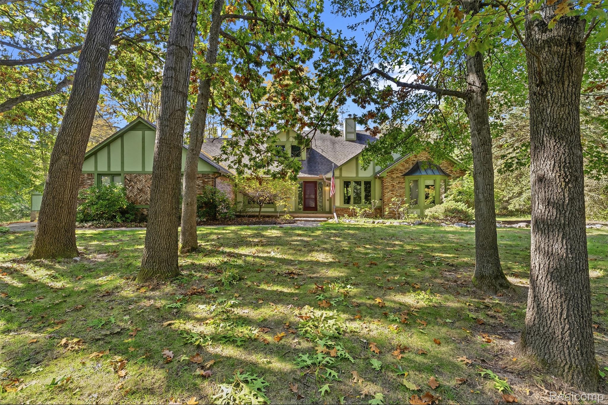 8135 Ranch Estates Road Clarkston, MI 48348 - Photo 2 of 53 Exterior featuring a prominent front lawn, mature trees, a multi-pane front door, and a bay window