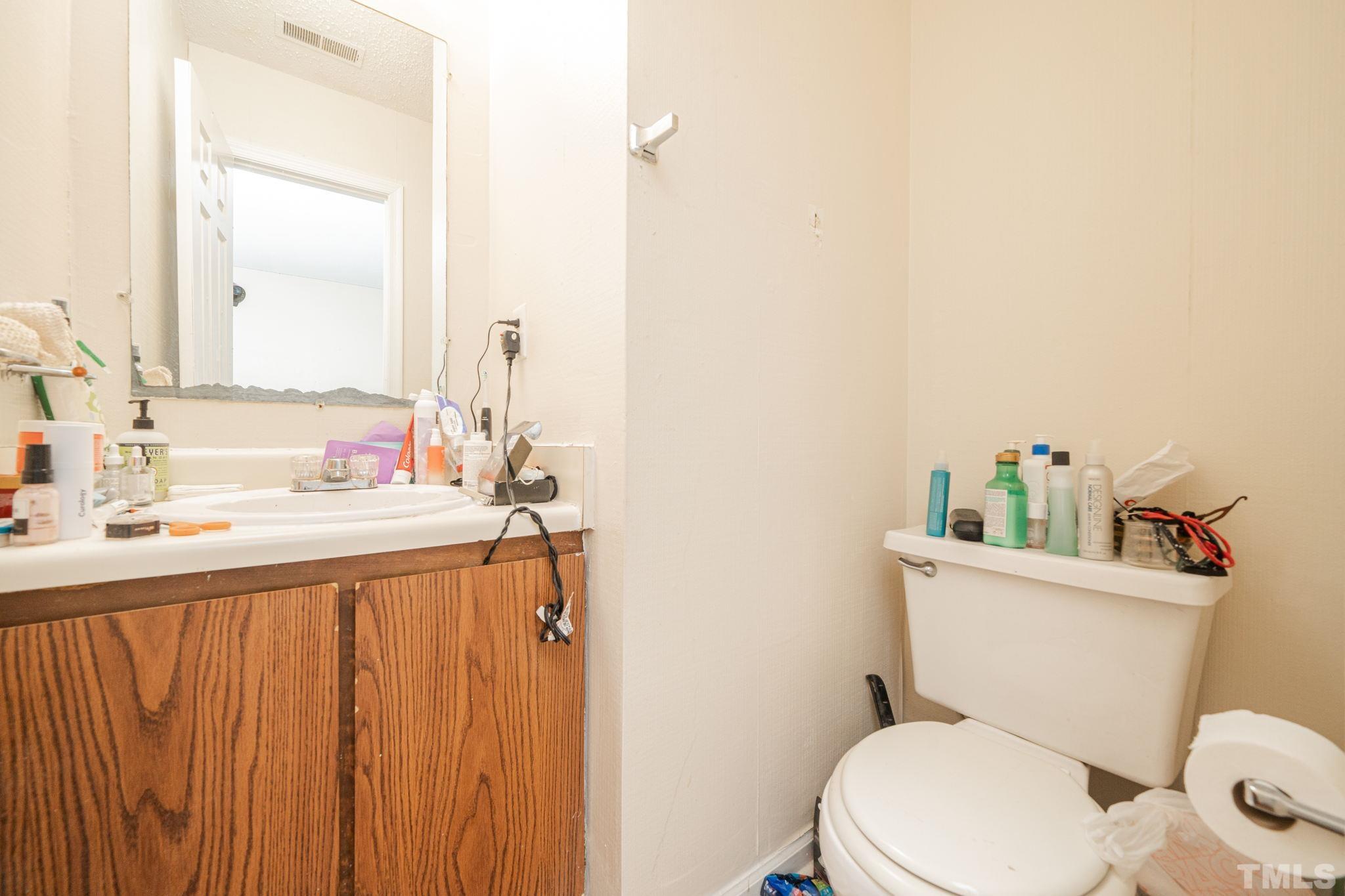 4304 Presley Court Raleigh, NC 27604 - Photo 29 of 34 a bathroom with a sink a toilet and mirror