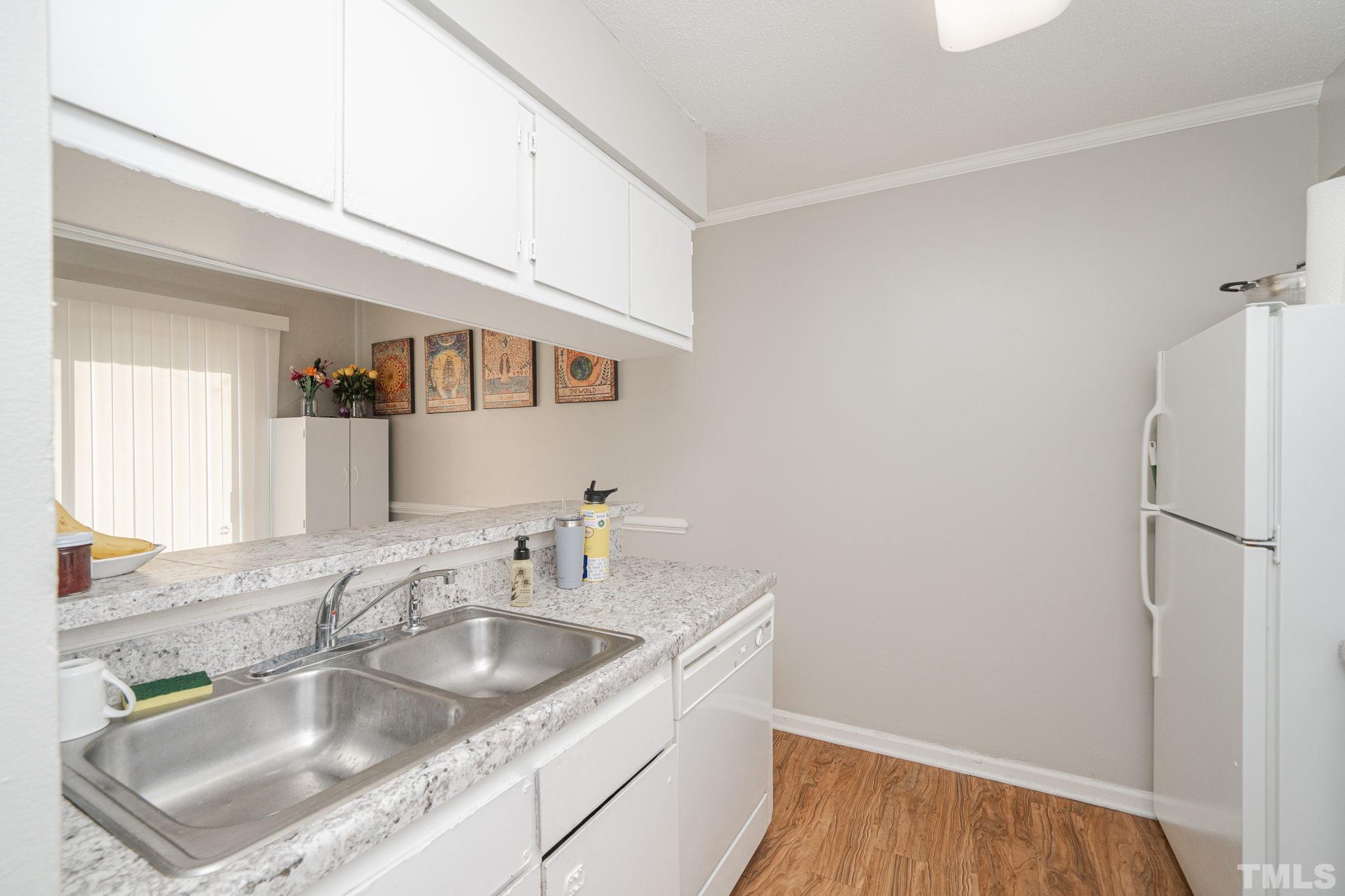4304 Presley Court Raleigh, NC 27604 - Photo 5 of 34 a kitchen with a sink and a refrigerator