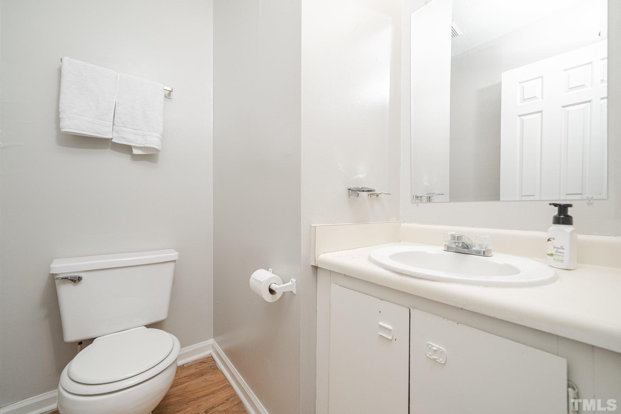 4304 Presley Court Raleigh, NC 27604 - Photo 8 of 34 a bathroom with a toilet sink vanity and mirror