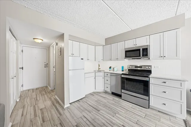 a kitchen with stainless steel appliances a stove a sink and a refrigerator