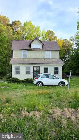 a view of a house with a yard and sitting area