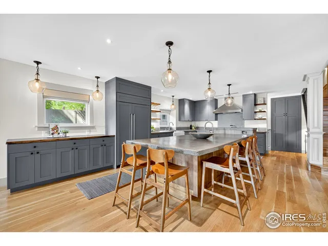 a kitchen with stainless steel appliances kitchen island granite countertop a refrigerator and a stove top oven