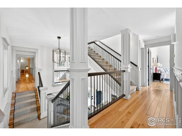 a view of a hallway with wooden floor and stairs