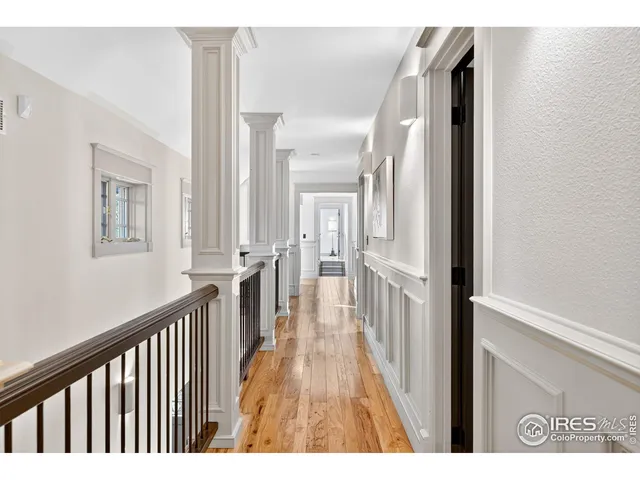 a view of a hallway with wooden floor and staircase