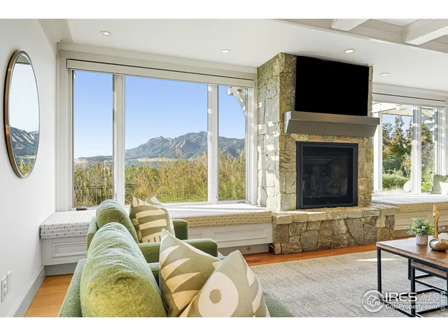 a living room with a fireplace a flat screen tv and a large window