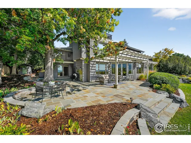 a view of a white house with a table and chairs