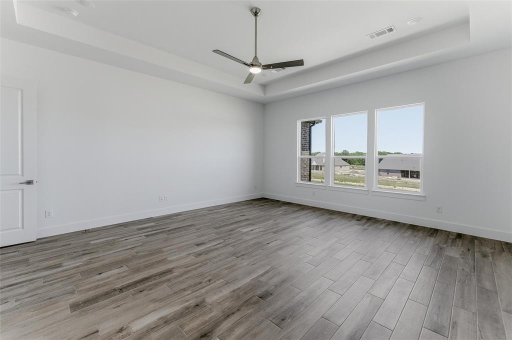 815 Vly Rdg Road Van Alstyne, TX 75495 - Photo 20 of 29 Spacious room featuring wood-finish flooring, a tray ceiling, and a modern ceiling fan
