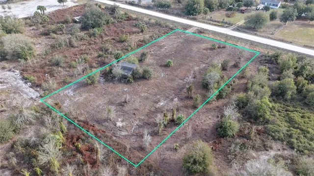 a view of a dry yard with wooden fence