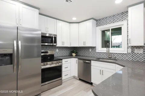 a kitchen with stainless steel appliances granite countertop a stove a sink and a refrigerator