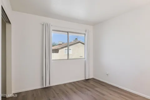an empty room with wooden floor and window