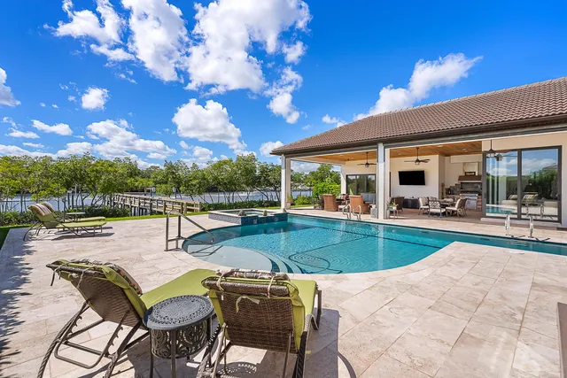 a view of a dining room with furniture a chandelier and a window