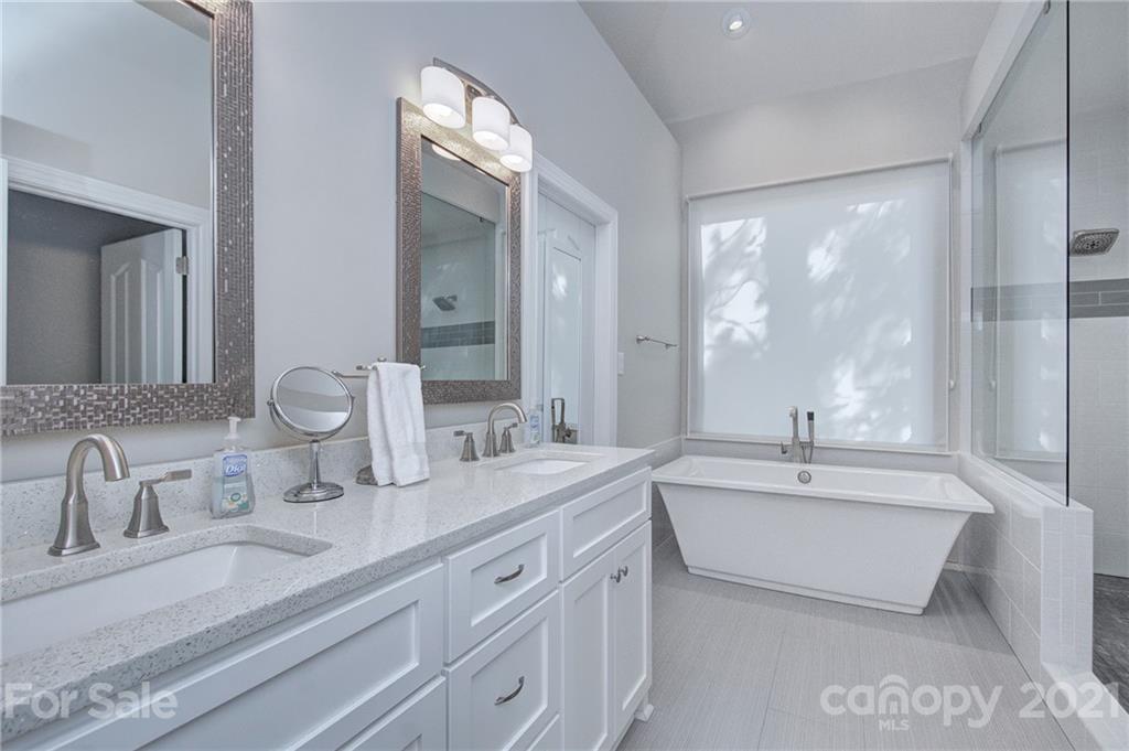 2064 McKee Road Fort Mill, SC 29708 - Photo 22 of 45 a bathroom with double vanity sinks a large mirror and a bathtub