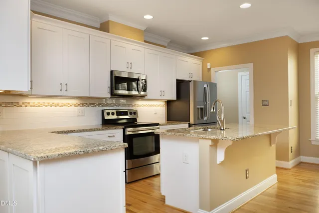 a kitchen with kitchen island granite countertop a sink stove and refrigerator