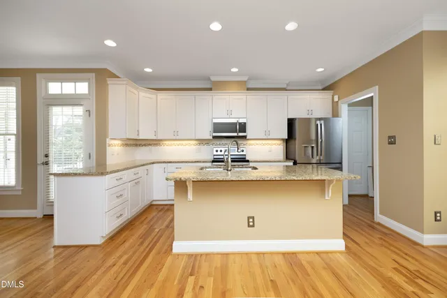 a large kitchen with stainless steel appliances granite countertop a stove a sink and a refrigerator