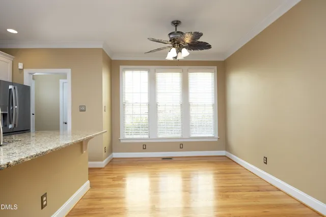 a view of an empty room with window and wooden floor