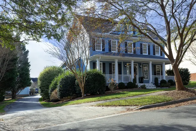 a front view of a house with a yard and trees
