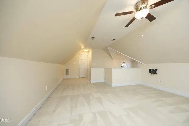 an empty room with ceiling fan and window