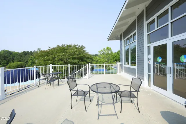 a roof deck with table and chairs