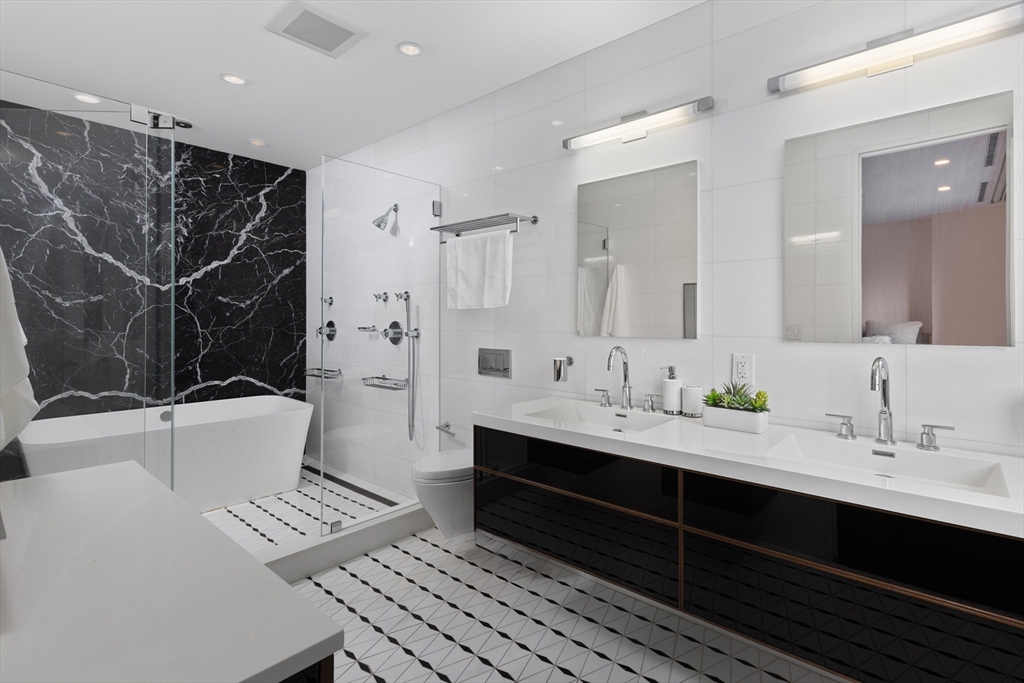 410 Beacon Street Boston, MA 02115 - Photo 25 of 35 a bathroom with a double vanity sink toilet mirror and bathtub