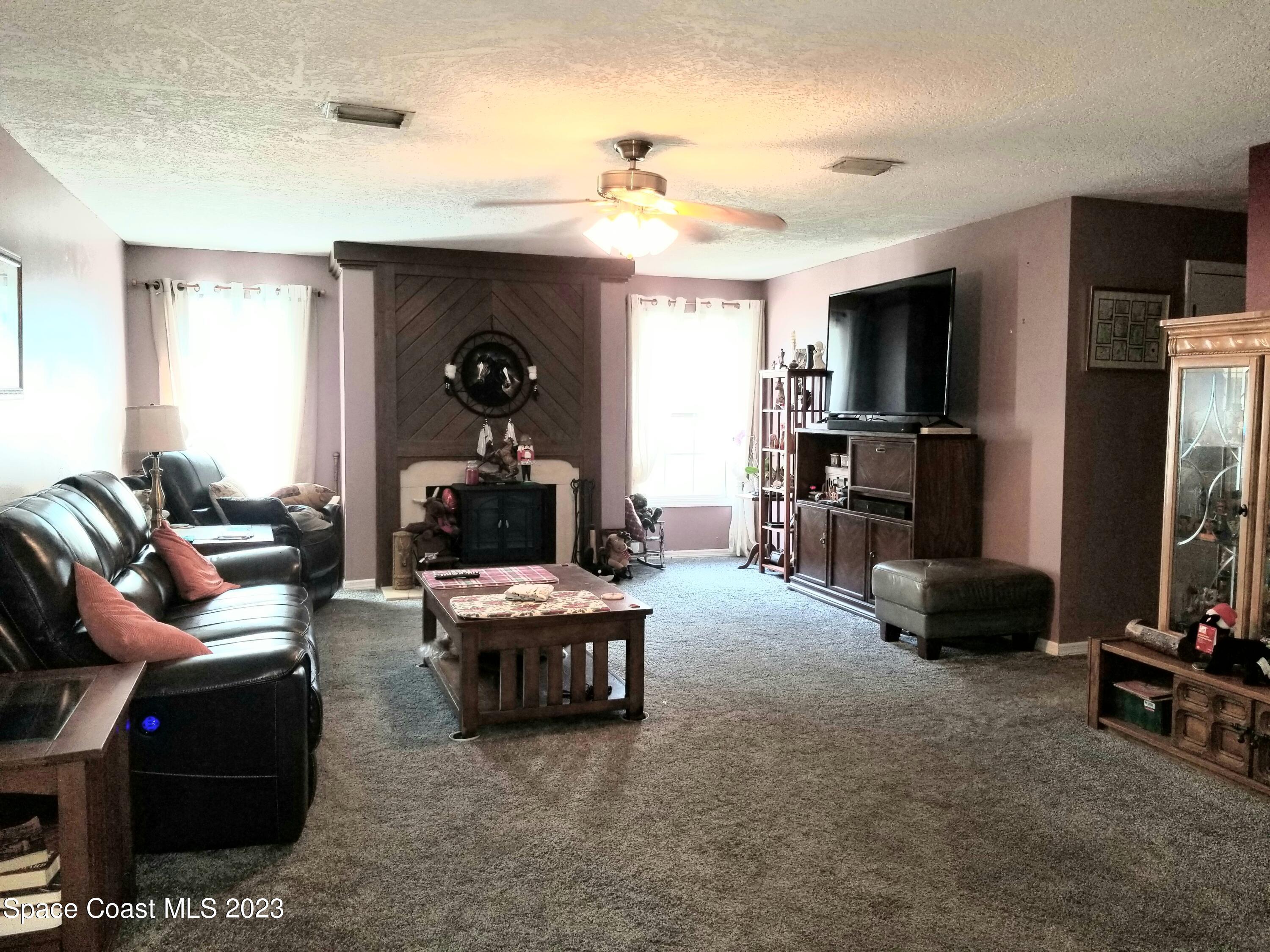 3700 Pine Cone Road Melbourne, FL 32934 - Photo 14 of 38 a living room with furniture and a flat screen tv