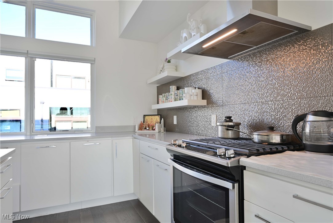 18875 Riversouth Terrace, Unit 35 Cleveland, OH 44126 - Photo 9 of 37 Kitchen with wall chimney exhaust hood, gas range, plenty of natural light, and backsplash