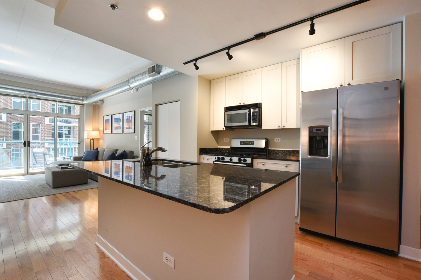 920 West Madison Street, Unit D4 Chicago, IL 60607 - Photo 12 of 34 a kitchen with granite countertop a refrigerator a sink a stove and cabinets