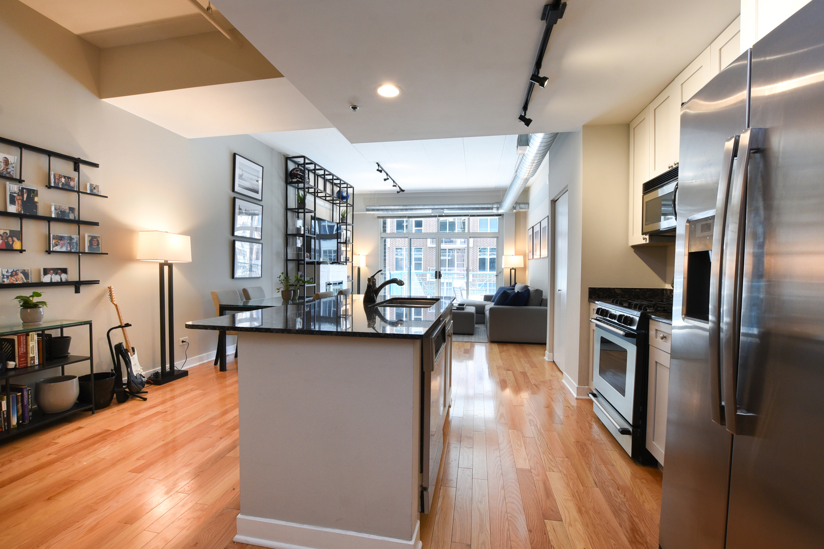 920 West Madison Street, Unit D4 Chicago, IL 60607 - Photo 14 of 34 a kitchen with stainless steel appliances kitchen island granite countertop a refrigerator a stove and a sink with cabinets
