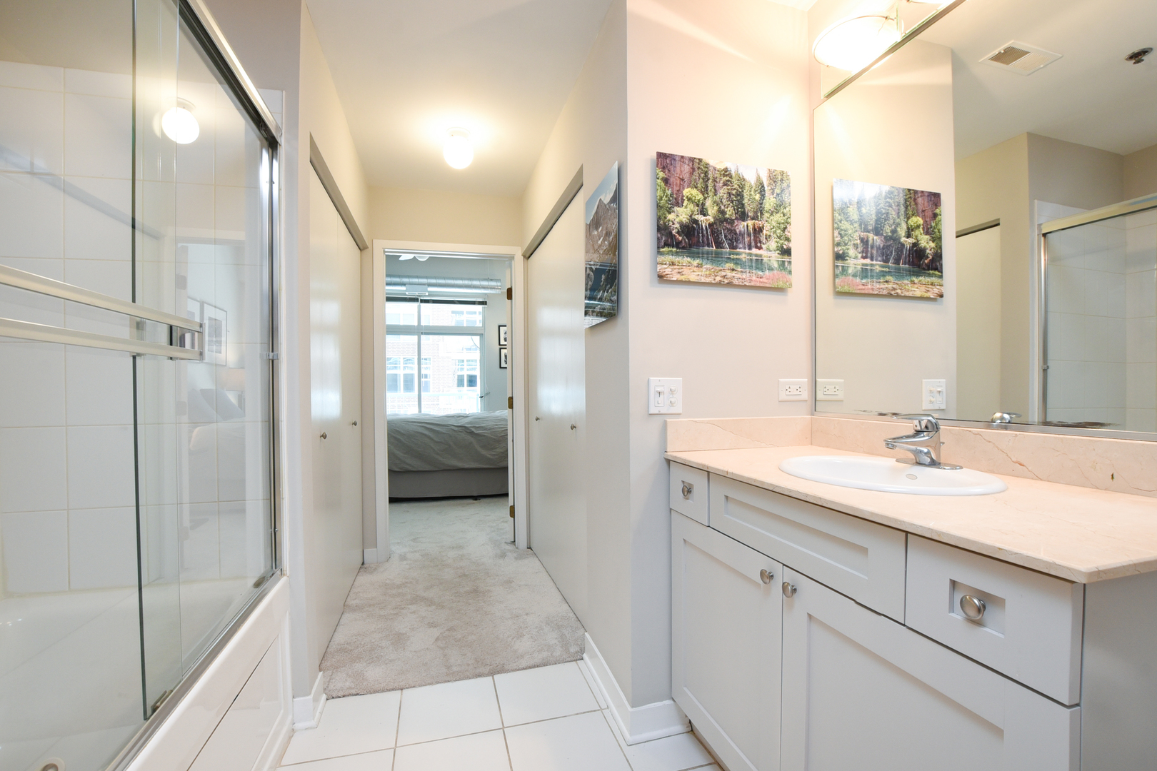 920 West Madison Street, Unit D4 Chicago, IL 60607 - Photo 20 of 34 a en suite bathroom with a granite countertop sink a mirror and a shower
