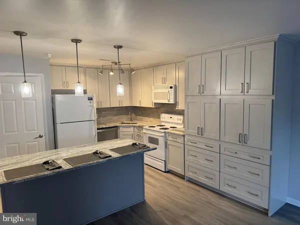 a kitchen with kitchen island white cabinets and stainless steel appliances
